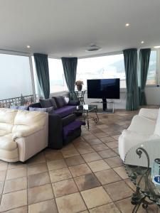 uma sala de estar com sofás e uma televisão de ecrã plano em Apartments Darijana em Opatija