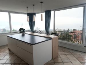 uma cozinha com grandes janelas e uma grande ilha de cozinha em Apartments Darijana em Opatija