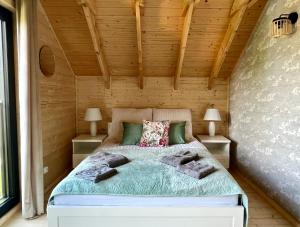 1 dormitorio con 1 cama en una pared de madera en DUO Dom Kopalino, en Kopalino