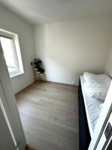 Nydelig perle rett ved fjorden في ساندنيس: غرفة نوم بسرير وارضية خشبية