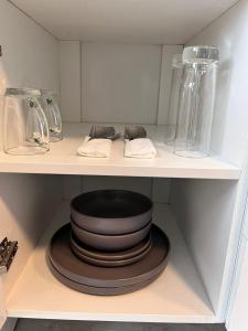 a shelf with a stack of plates and glass vases at De Tuin Accommodation in Cape Town