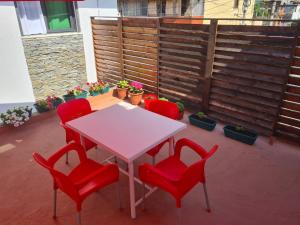 una mesa blanca y 4 sillas rojas en un patio en VILA 32, en Berat
