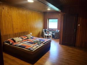 1 dormitorio con 1 cama en una habitación con paredes de madera en Apartmány GUGEL MLYNKY, en Mlynky 