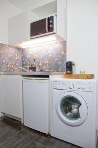 una cucina con lavatrice e forno a microonde di Studio Lumineux proche de Paris et Disneyland a Villemomble