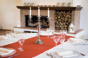a table with wine glasses and a candle holder on it at Casale Fornello in Acquapendente