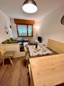ein Wohnzimmer mit einem Tisch und einem Sofa in der Unterkunft Bucaneve in Tarvis