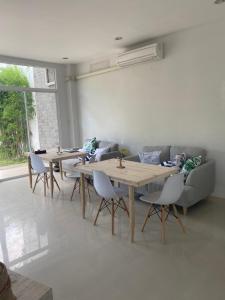 un soggiorno con tavoli e divano di The CHU cafe / guesthouse a Nai Harn Beach