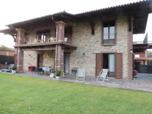 une maison en briques avec une terrasse et une pelouse dans l'établissement B&B CASA BELLA COMBA, à Vignolo