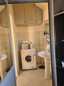 małą łazienkę z pralką i umywalką w obiekcie VILA 32 w mieście Berat