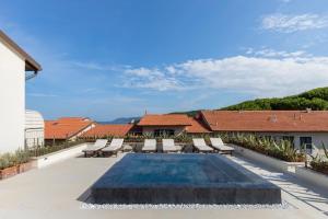 a swimming pool on the roof of a house at Villa Martini in Castiglioncello