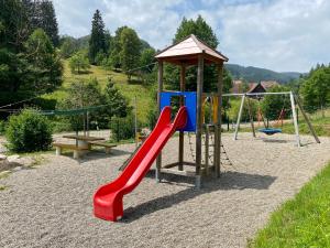 a playground with a red slide and a bench at *Schwarzwald-Apartment 1° * in Elzach