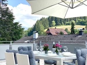 - une table avec des chaises et un parasol sur la terrasse dans l'établissement *Schwarzwald-Apartment 1° *, à Elzach