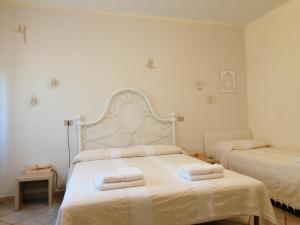 een slaapkamer met 2 bedden en handdoeken bij Villa Oasi in San Giuliano Terme