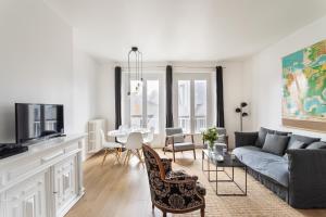 ein Wohnzimmer mit Sofa und Tisch in der Unterkunft Le Nuage Malouin - Appt à 300m de la plage in Saint-Malo + 5 Fotos