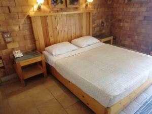 a bedroom with a large bed and a night stand at Tobya Village Hotel in Taba