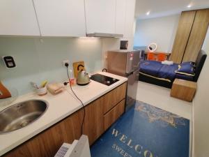 a kitchen with a sink and a bed in a room at Kozi Square Studio in Kuching