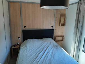 Un dormitorio con una cama con una manta azul. en Cottage, en Jullouville-les-Pins
