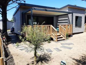 uma pequena casa com um alpendre e um deque em Cottage em Jullouville-les-Pins