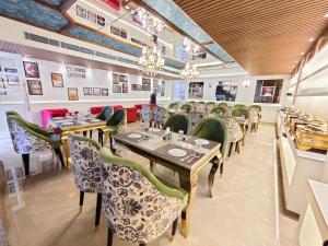 een eetkamer met tafels, stoelen en kroonluchters bij Hotel ND Manor in Dehradun