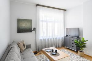 een woonkamer met een bank en een tv bij Grand Hotel Residents in Tartu
