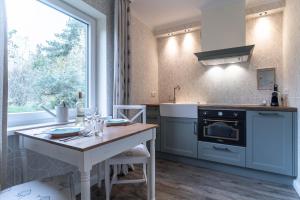 a kitchen with a table and a stove top oven at Hotel TWEED in Sankt Peter-Ording