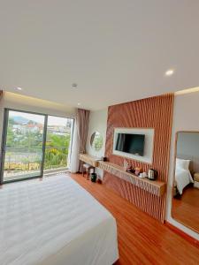 1 dormitorio con 1 cama grande y TV en Sunflower Hotel & Resort, en Bao Loc