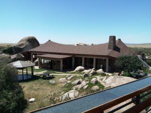 ein Haus mit einem Hof mit Felsen davor in der Unterkunft Seronera Wildlife Lodge in Serengeti-Nationalpark