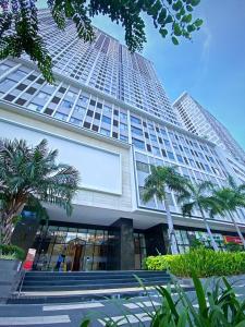 un grand bâtiment avec des palmiers devant dans l'établissement YourHomes - River Gate, à Hô-Chi-Minh-Ville