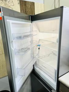 an empty refrigerator with its door open in a kitchen at Nowomiejska Blisko Centrum in Suwałki