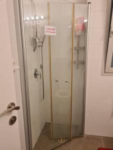 a shower with a glass door with a sign on it at Best Place to relax in Tel Aviv in Tel Aviv