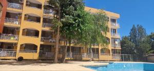 an apartment building with a swimming pool in front of it at Complex Dobrudja in Kranevo
