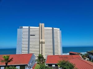 a large white building in front of the ocean at 146 Stella Maris Durban Amanzimtoti in Amanzimtoti