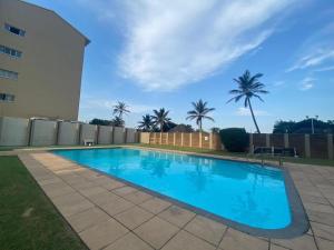 a swimming pool in a yard next to a building at 146 Stella Maris Durban Amanzimtoti in Amanzimtoti