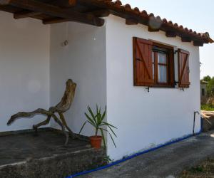 Biały dom z oknem i rośliną w obiekcie Anastasios House w Koroni
