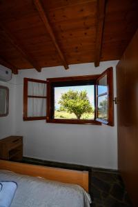 sypialnia z łóżkiem i oknem w obiekcie Anastasios House w Koroni