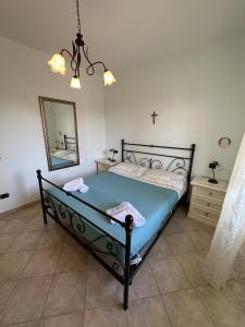 - une chambre avec un lit avec un miroir et une croix sur le mur dans l'établissement CASA CELESTE, à Bordighera