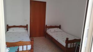 two twin beds in a room with a door at Home in Vlorë