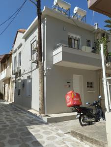 a scooter parked next to a building with a red bag on it at Arcade City Apartment in Rethymno