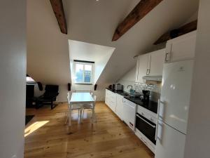 a kitchen with white cabinets and a table at Home Inn VMG in Stockholm