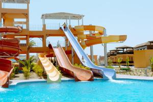 a water slide in a pool at a resort at Pickalbatros Villaggio Aqua Park - Portofino Marsa Alam in Marsa Alam City