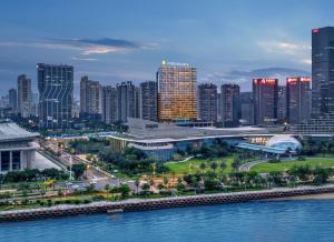 eine Skyline der Stadt mit hohen Gebäuden und einem Fluss in der Unterkunft InterContinental Xiamen, an IHG Hotel in Xiamen
