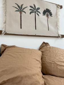 a picture of palm trees on a wall above a bed at Five and You in Josse