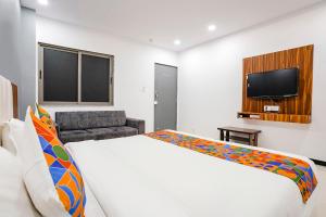 a hotel room with a bed and a television at FabHotel Magnus in Surat