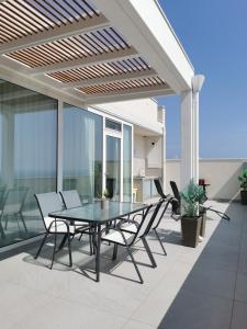 eine Terrasse mit einem Tisch und Stühlen auf dem Balkon in der Unterkunft Appartamento Sul Golfo in Castellammare del Golfo