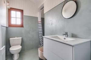 une salle de bain avec un lavabo, des toilettes et un miroir dans l'établissement 8 adultes - 2 enfants - Marais salants et plages, à Noirmoutier-en-l'lle 25 autres photos