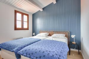 une chambre avec un lit avec un mur bleu dans l'établissement 8 adultes - 2 enfants - Marais salants et plages, à Noirmoutier-en-l'lle