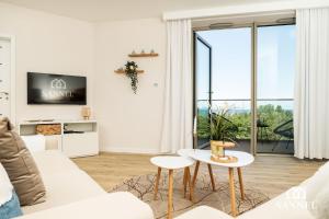 a living room with a white couch and a table at Apartament Premium Sea-Pinea Apartments Pobierowo in Pobierowo