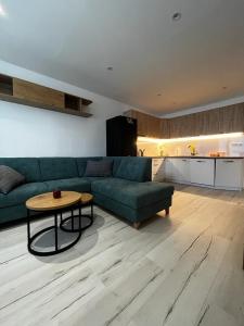 ein Wohnzimmer mit einem grünen Sofa und einem Tisch in der Unterkunft Apartmán Lúčky Bojnice in Bojnice