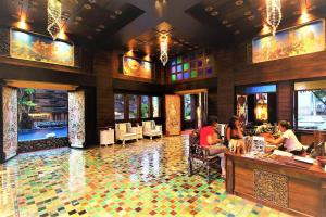 a lobby of a restaurant with people sitting at a counter at Singha Montra Lanna Boutique Style Hotel in Chiang Mai