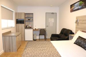 a hotel room with a bed and a kitchen at Childers Oasis Motel in Childers